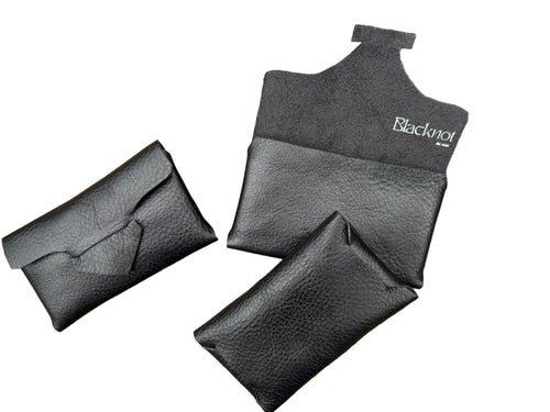 A black textured leather cardholder or pouch The pouch is open, showing the interior and a white 'Blacknot' brand logo printed on the inside flap.