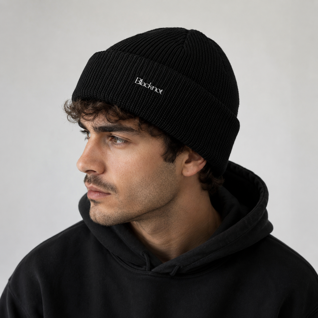 Man wearing a black ‘Blacknot' beanie 
